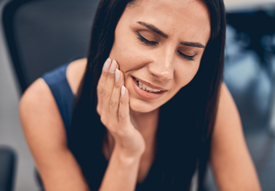 Person holding their jaw before an emergency dental appointment near North Manly